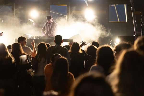 DJ en concert avec fumée et lumières dorées